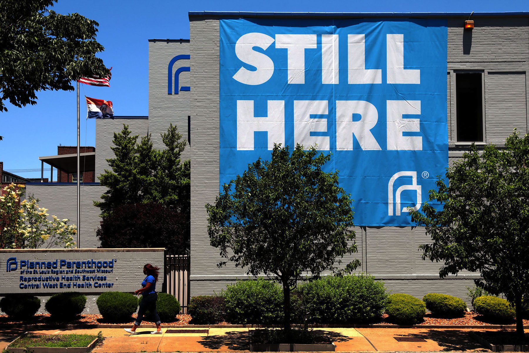 A banner that reads "Still Here" hangs on the side of the Planned Parenthood of St. Louis building.