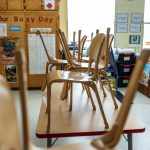 Wooden chairs are stacked on top of tables inside a classroom at the Chambliss Center for Children.