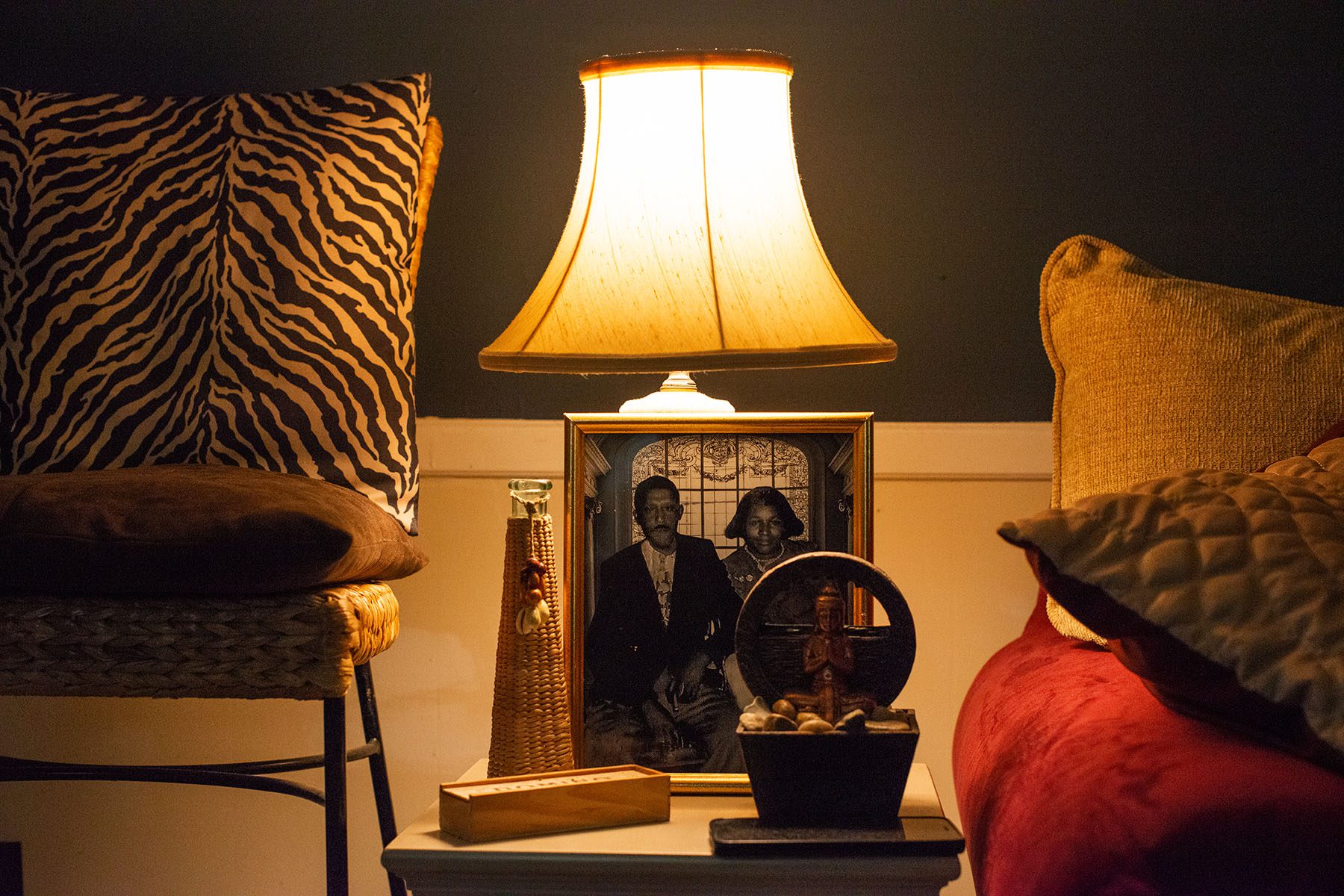 A framed photograph of a black couple sits beside a couch.