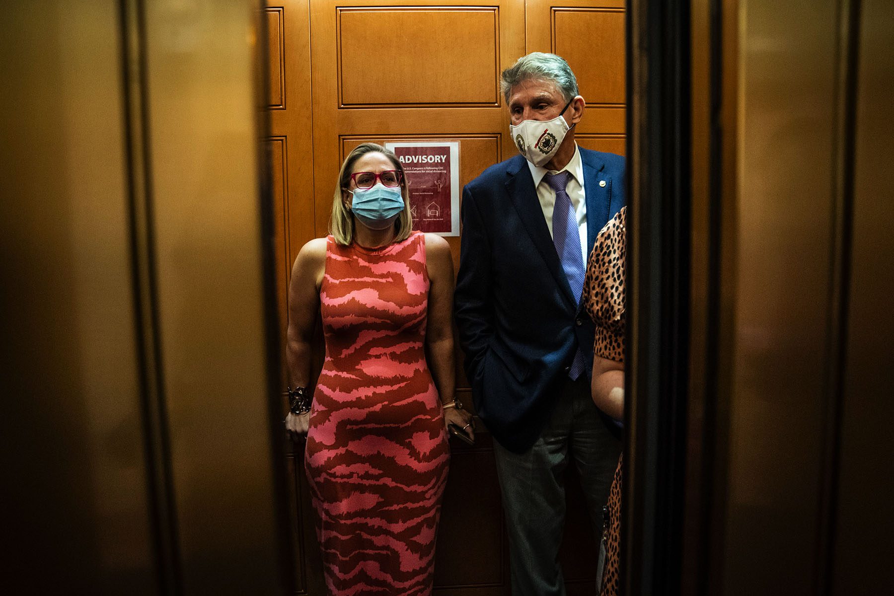 Kyrsten Sinema and Joe Manchin board an elevator.