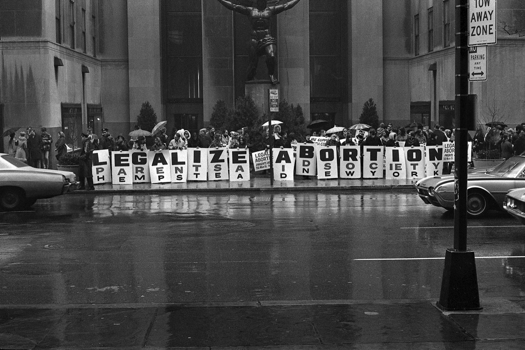 Activists hold a series of signs that read 'Legalize Abortion' during a demonstration.