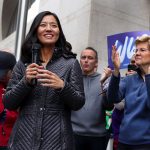 Michelle Wu and Elizabeth Warren are surrounded by supporters.