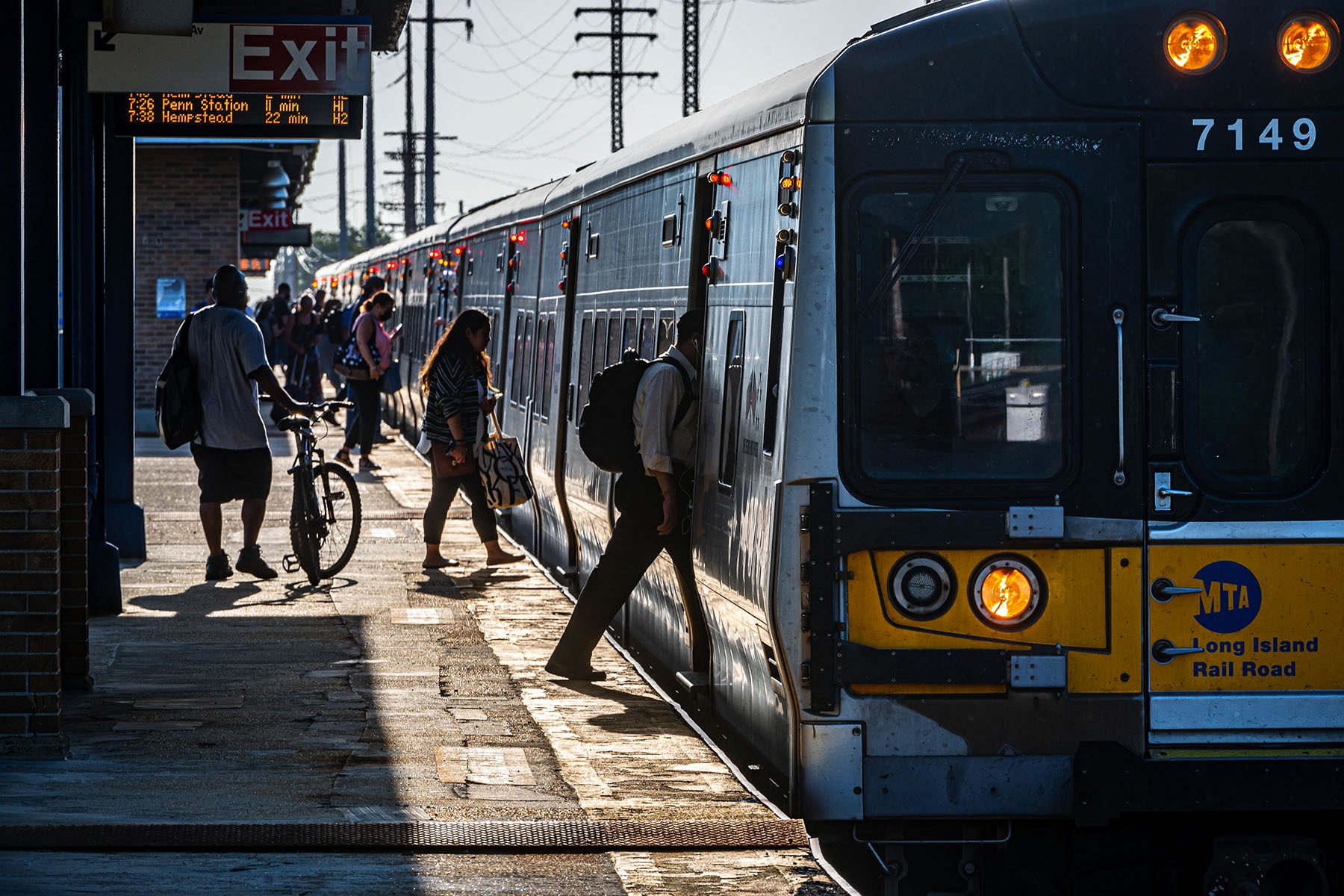 Commuters board a train at a Long Island Rail Road station.