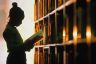 A young girls looks at book in a library.