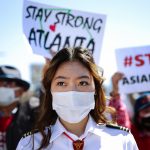 A woman wearing a face mask is pictured at a demonstration.