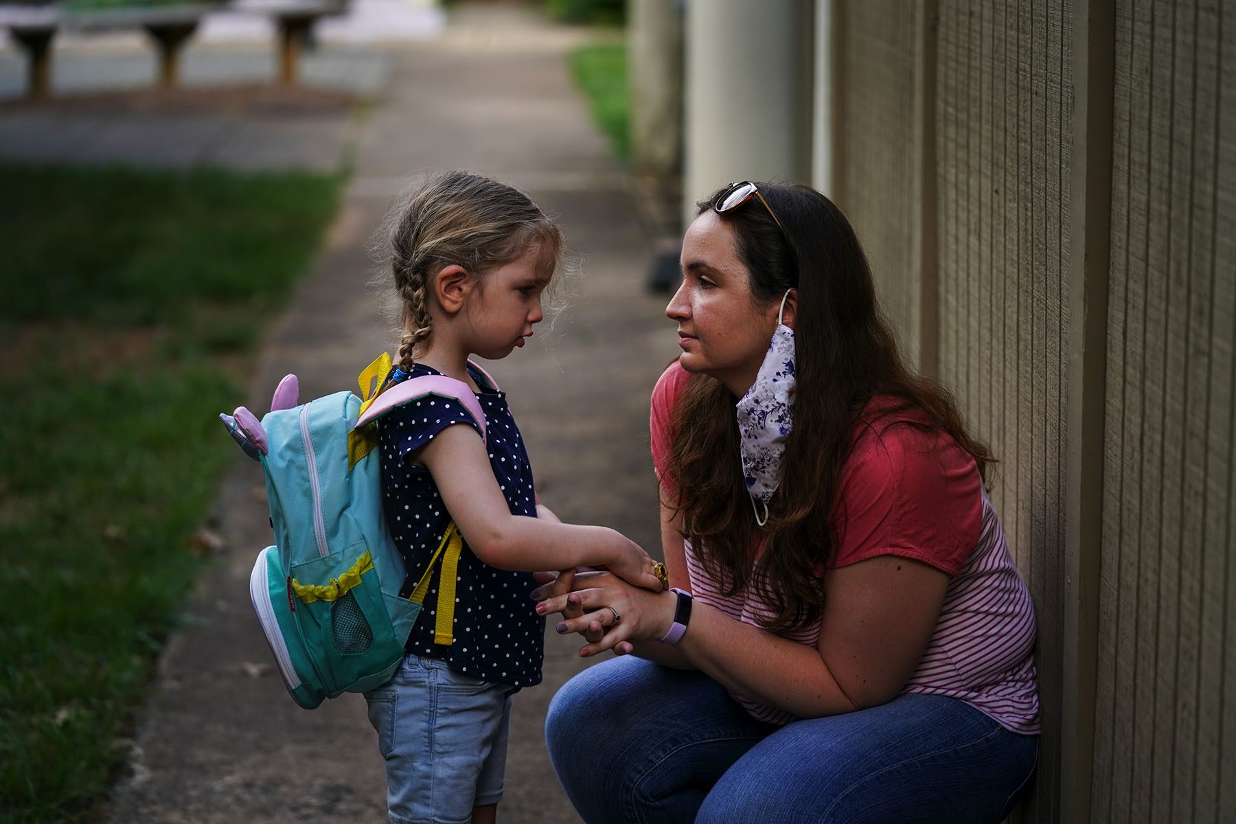 A mom consoles her young child before they depart for daycare.