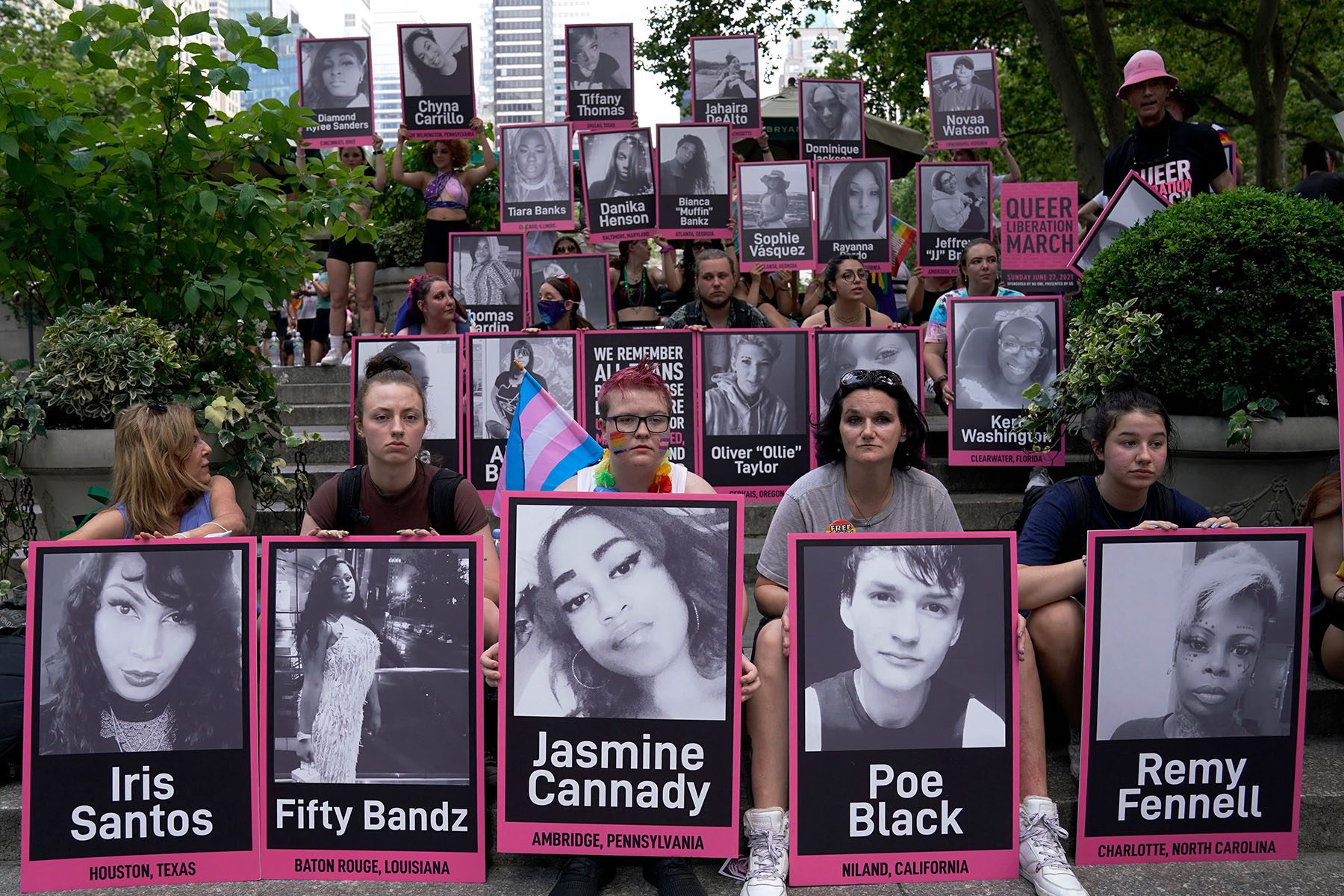 People hold photos of murdered transgender people.