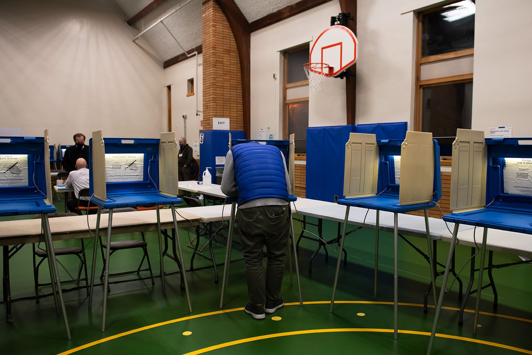 People fill out their ballots at a school.