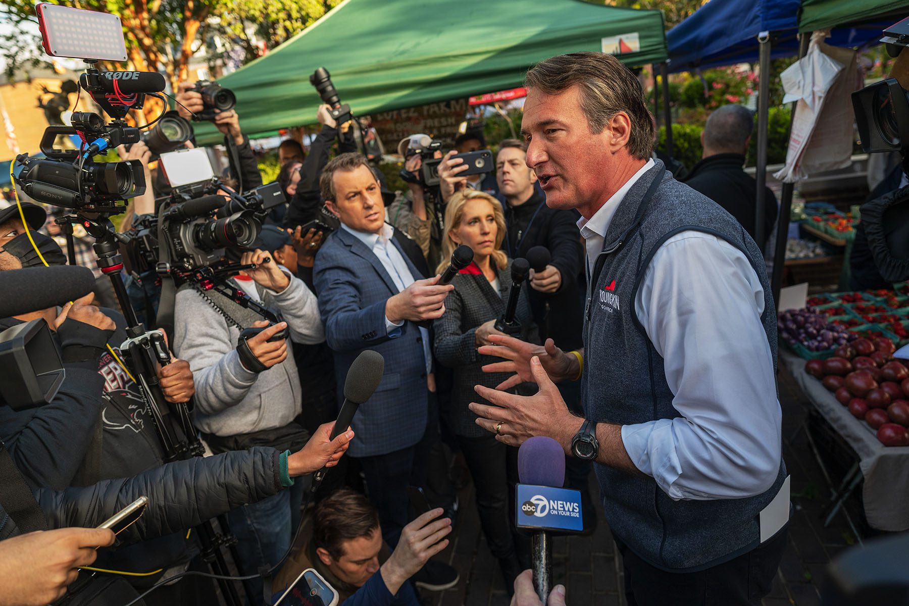 Glenn Younkin speaks to the media at a farmer's market.