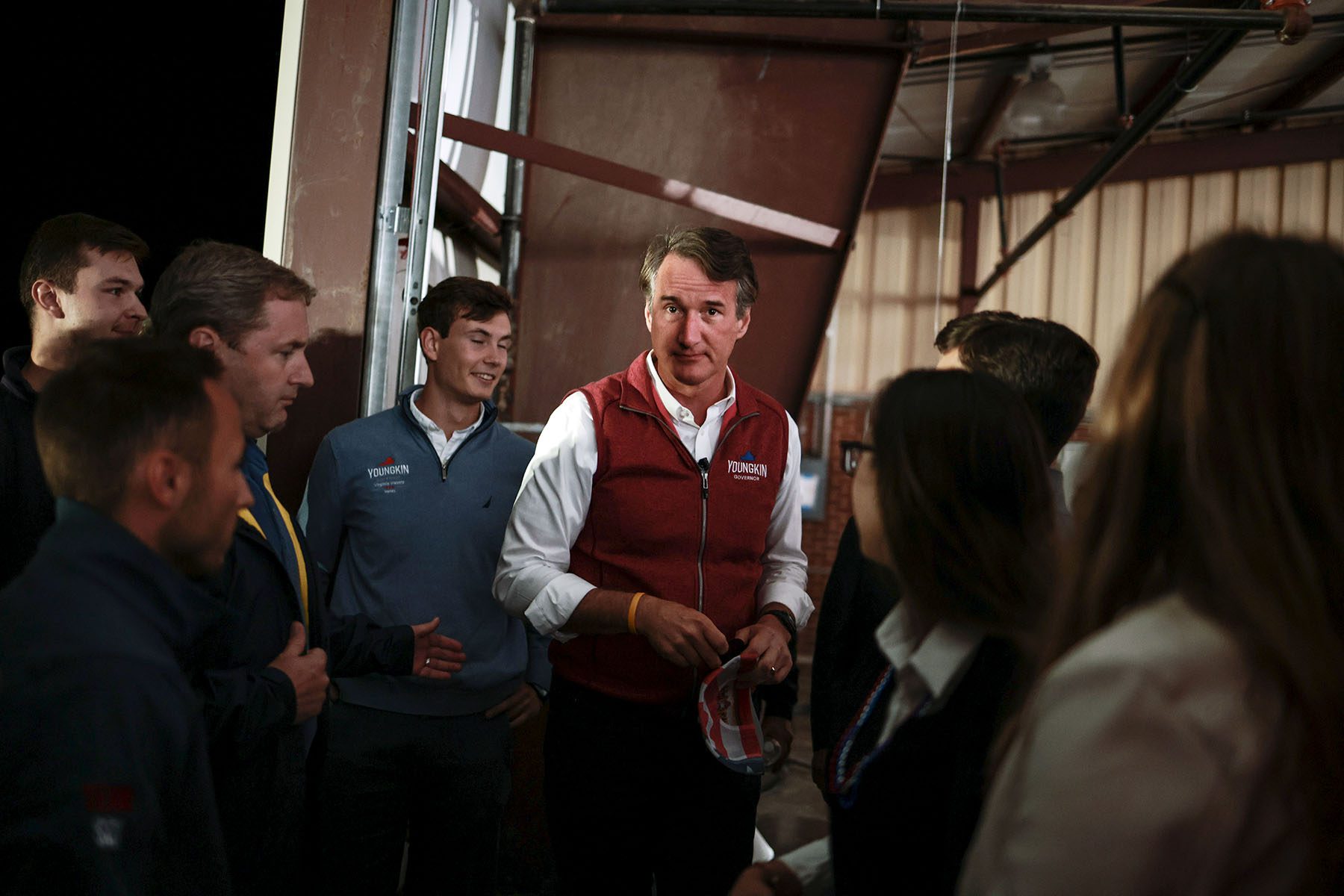 Glenn Youngkin looks at the camera. He is surrounded by campaign staff and supporters.