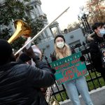 Activists hold signs calling on President Biden to cancel student debt near the White House.