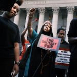 A teary-eyed woman holds her fist up during a protest against solitary confinement in New York City.