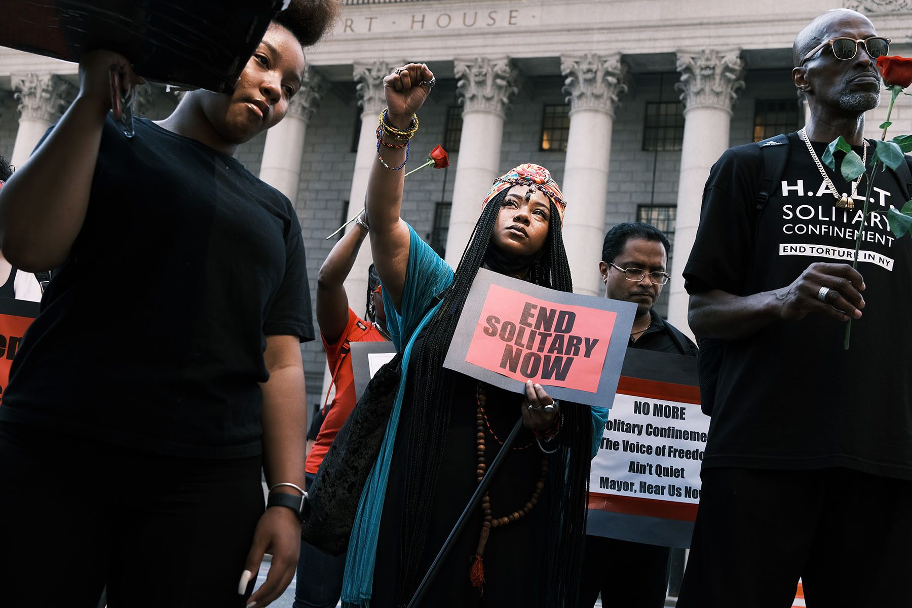 A teary-eyed woman holds her fist up during a protest against solitary confinement in New York City.