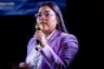 Jessica Cisneros holds a microphone as she addresses the crowd at a rally.