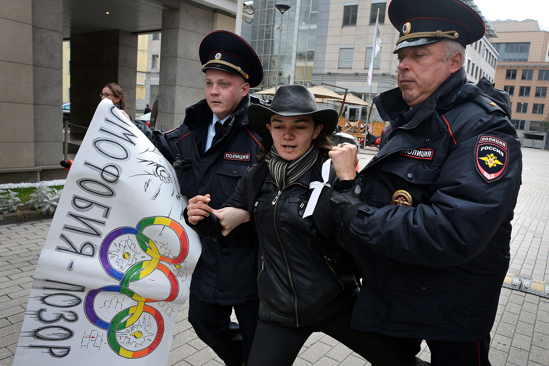 Police officers detain an activist.