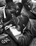 Teenagers lay down around a small transistor radio.