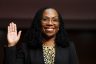 Ketanji Brown Jackson lift her hand as she is being sworn in to testify on Capitol Hill.