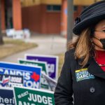 A volunteer waits near a polling station.