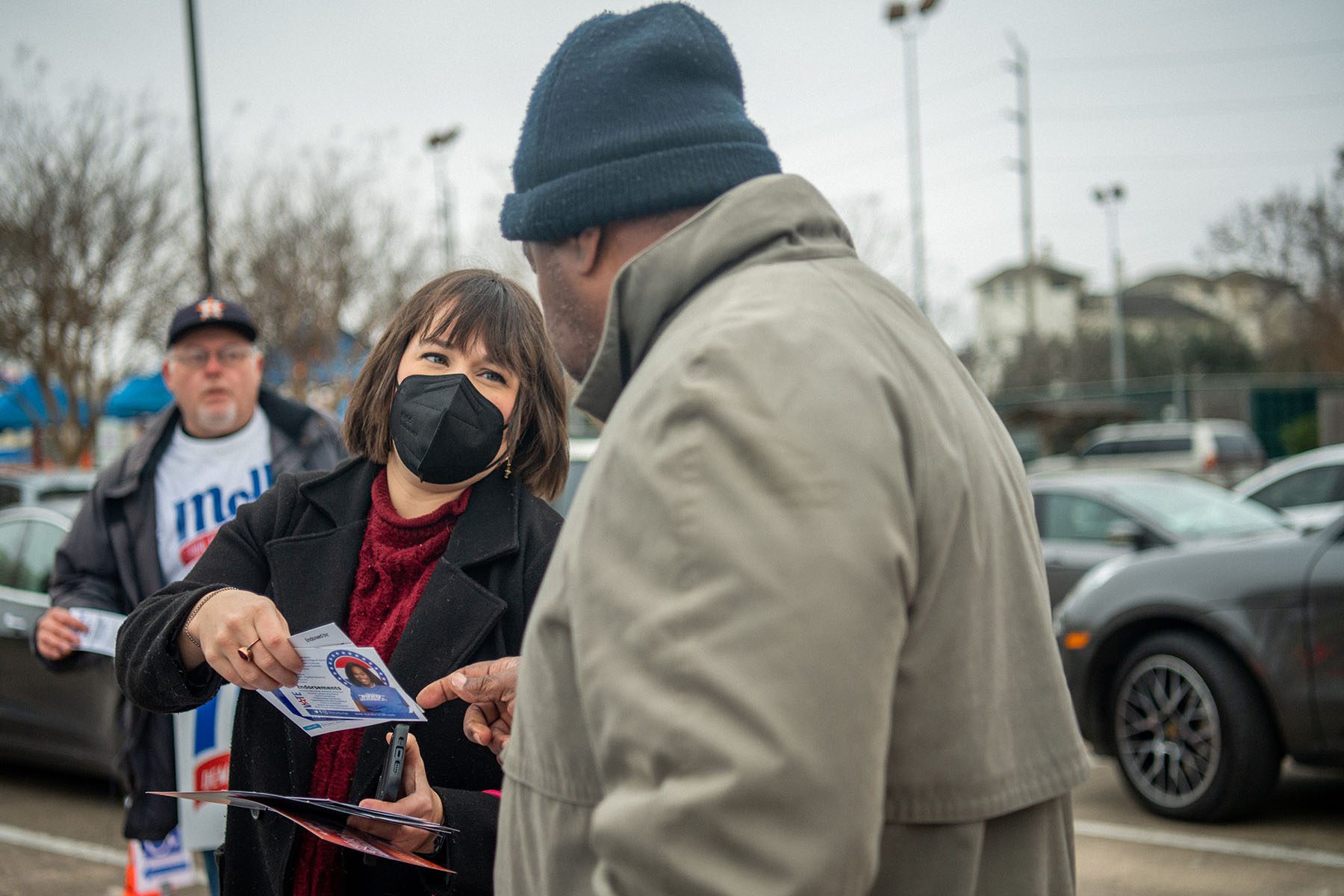 A poll worker greets a voter near a polling station.