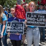 Pro-life protesters stand near the gate of the Texas state capitol.