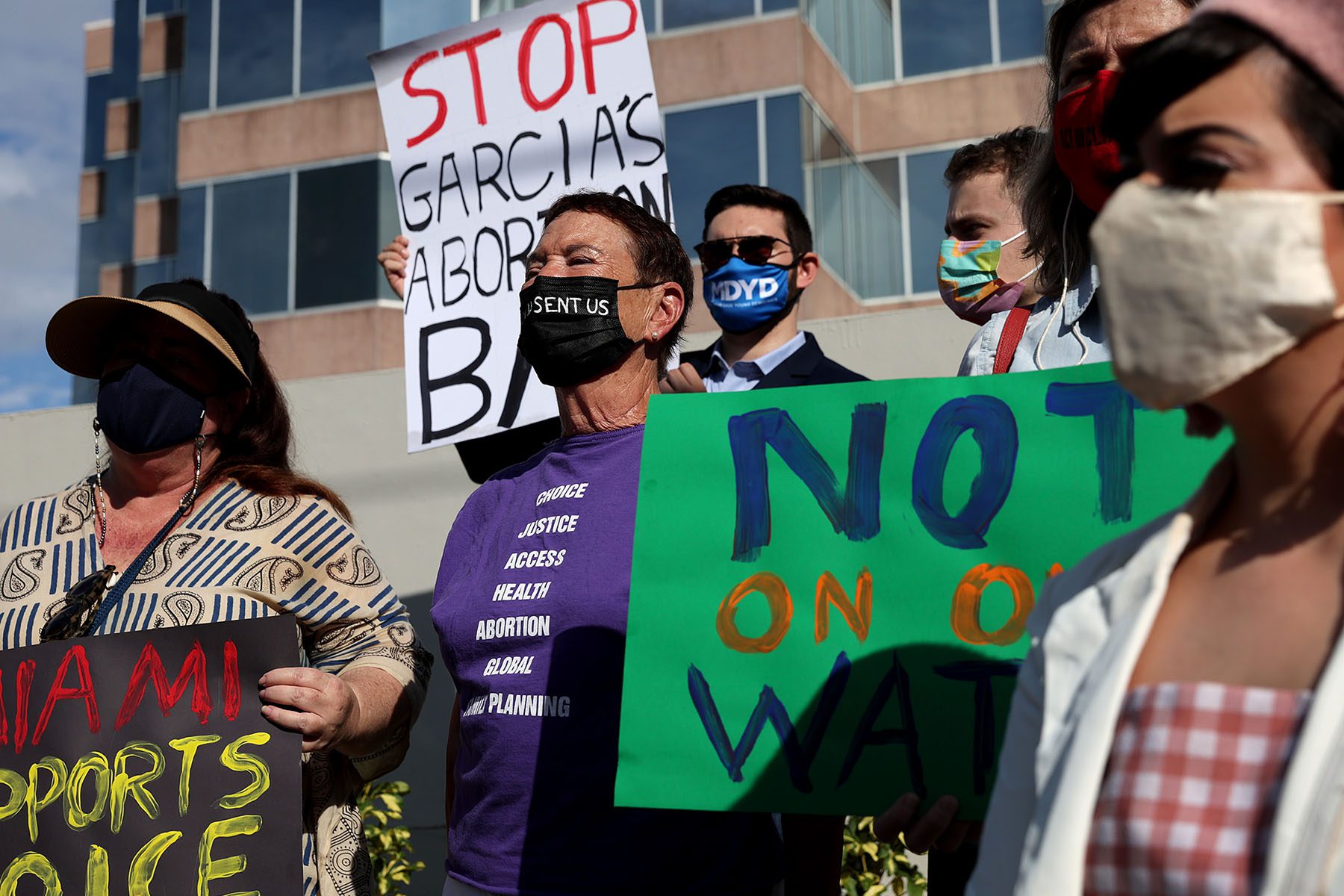 Abortion rights activists hold signs that read "Stop Garcia's Abortion Ban" and "Miami Supports Choice."