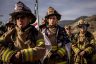 Firefighters in full gear observe a moment of silence.