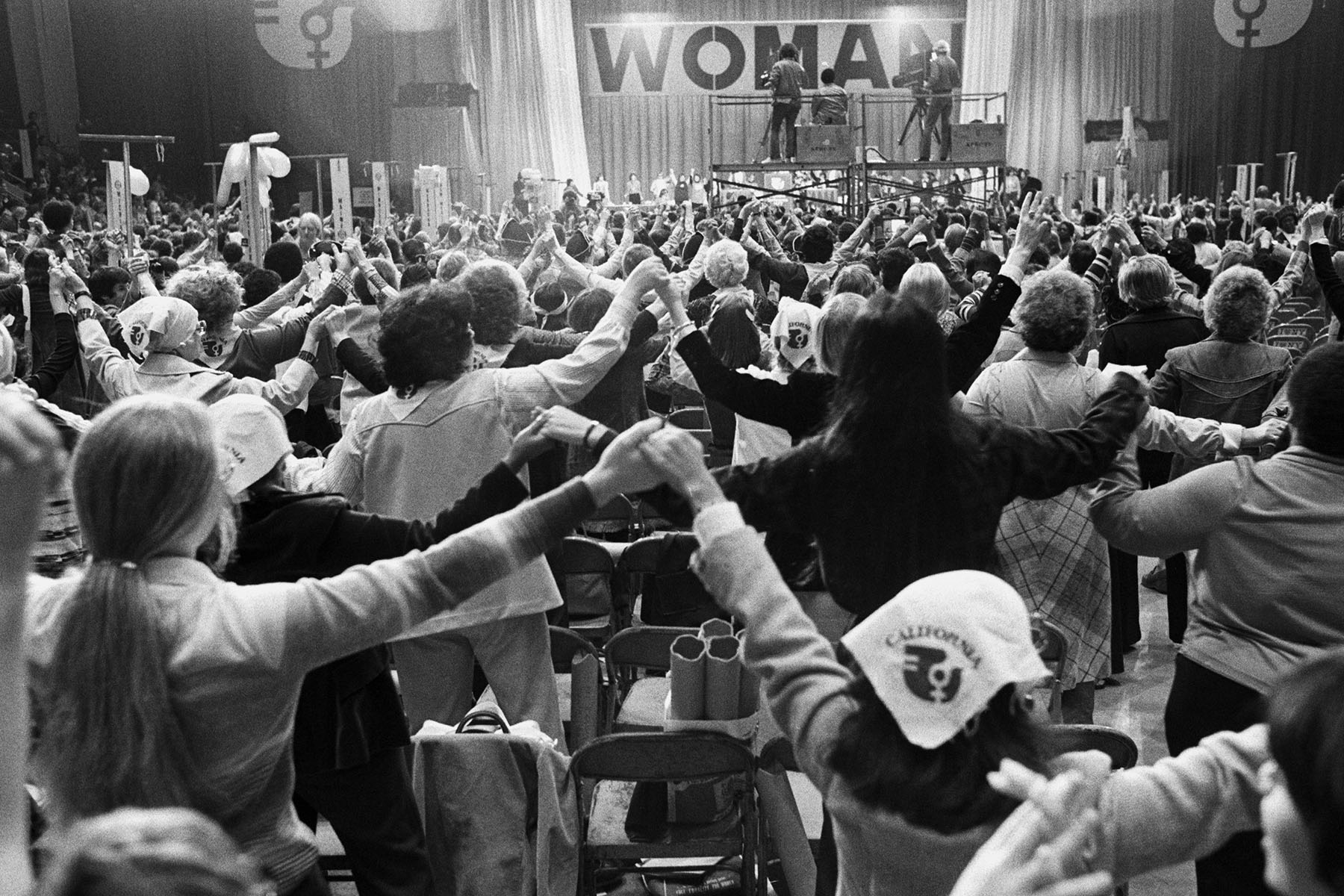 A room full of delegates join hands in a symbolic show of unity.