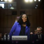 Judge Ketanji Brown Jackson smiles as she arrives at her confirmation hearing.