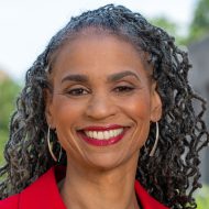 Woman with black curly hair wearing red lipstick