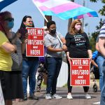 People holding signs that read 