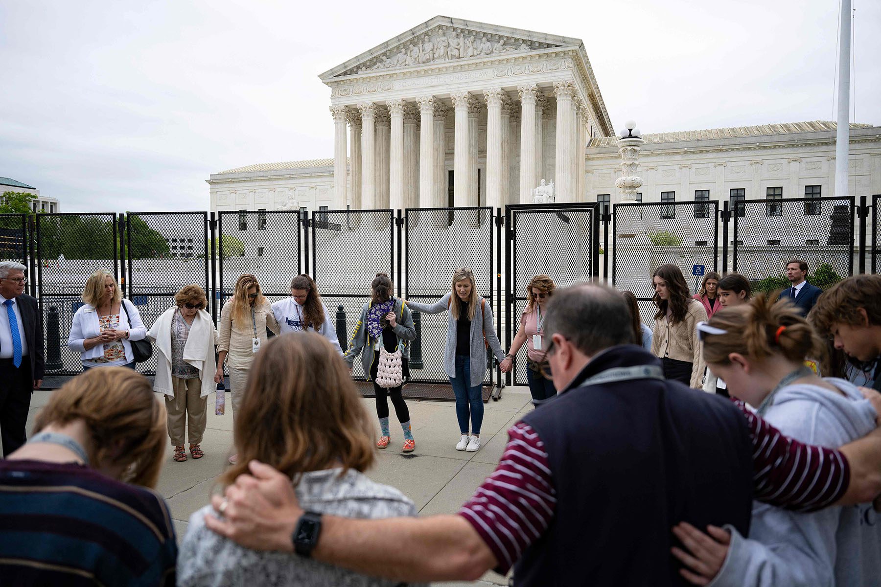 Anti-abortion demonstrators form a prayer circle in front of the Supreme Court.