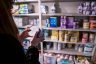 Katie Wussler checks the lot number under a can of baby formula in a storage closet containing baby supplies.