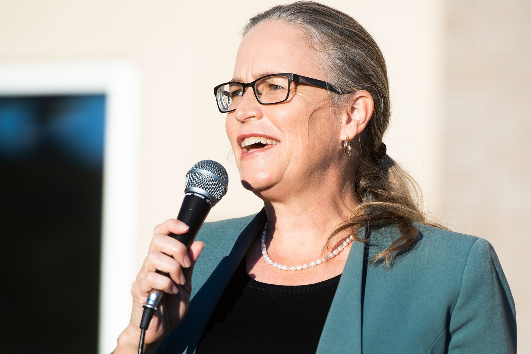 Carolyn Bourdeaux speaks into a microphone during a campaign rally.