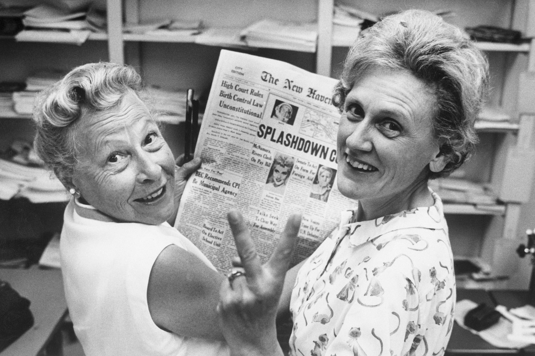 Estelle Griswold and Ernest Jahncke flash a victory sign while holding up a newspaper that reads "high court rules birth control law unconstitutional."