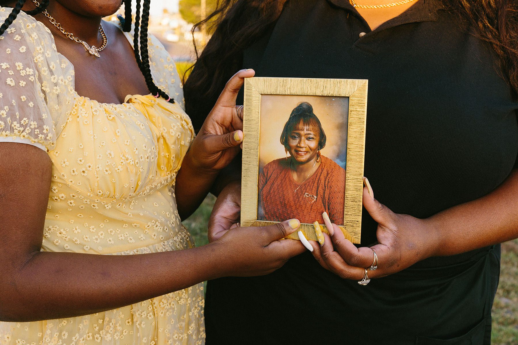 Ashley Manning and daughter Rhiley hold a photograph of Ashley's grandma who passed away from COVID-19.