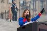 Janice McGeachin stands at a podium and holds a microphone as she speaks on the steps of the Idaho Statehouse.