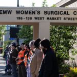 Anti-abortion rights demonstrators and clinic escorts stand in front of the EMW Women's Surgical Center.