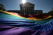 A giant LGBTQ+ pride flag is seen in front of the Supreme Court.