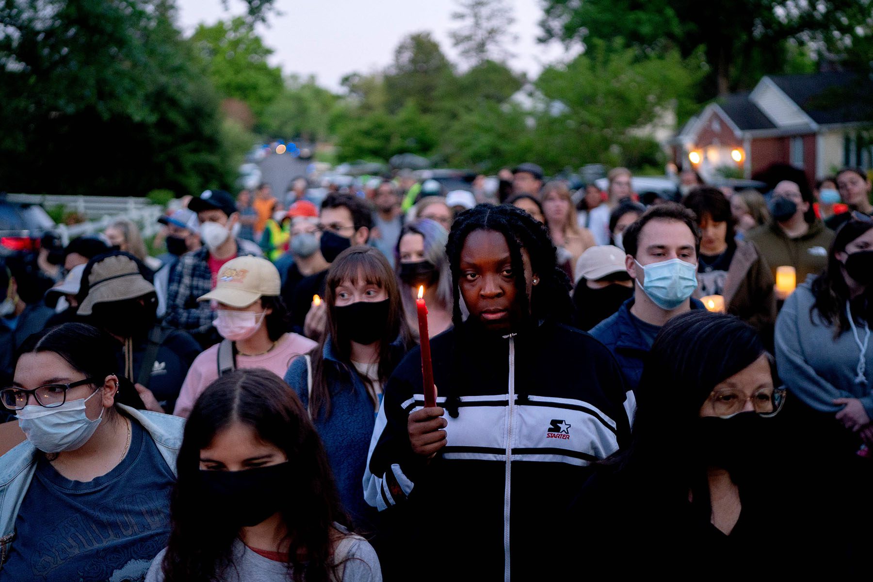 A woman holds a lit candle in the middle of a crowd of abortion rights activists.