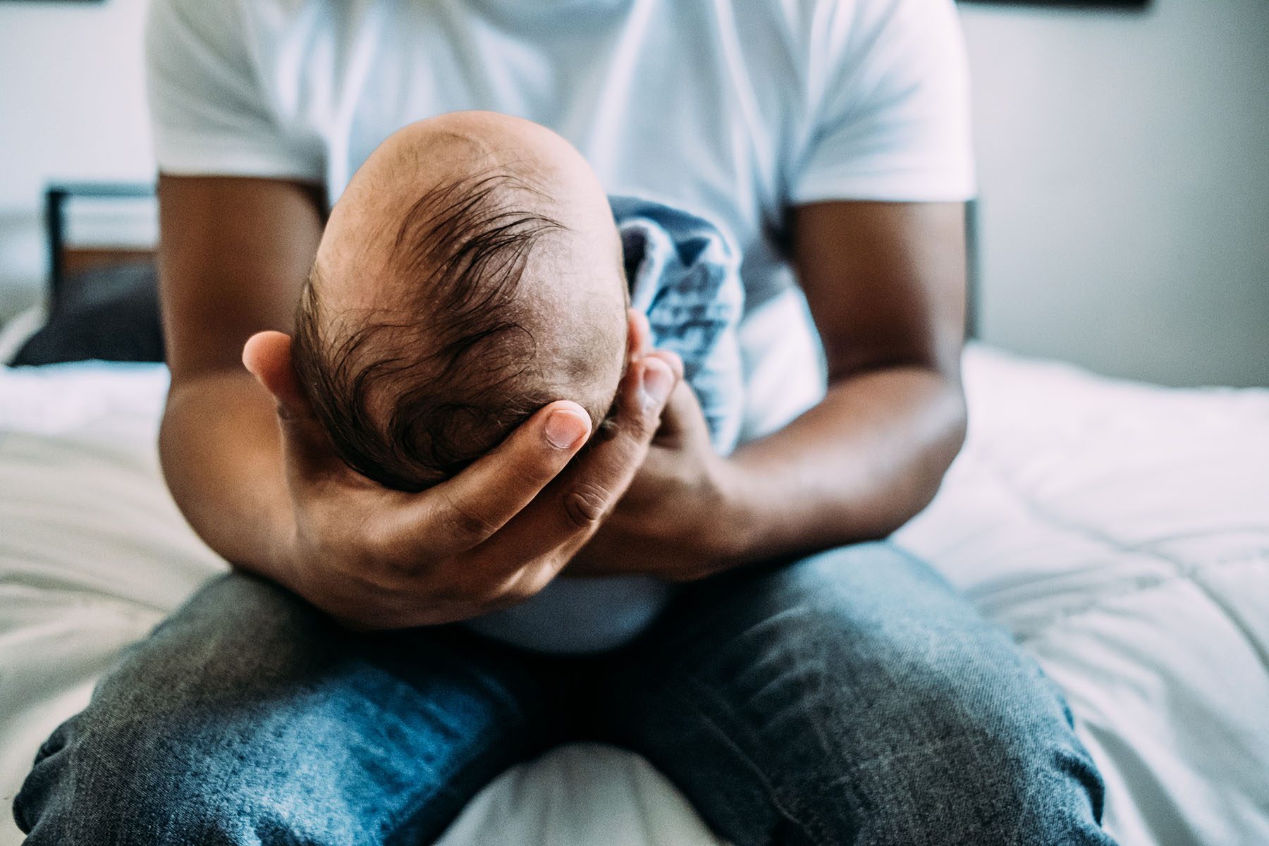 portrait of dad holding newborn baby