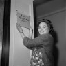 Rep. Patsy Mink holds a homemade plate that reads "Rep. Patsy T. Mink (D-Hawaii)" on her new Capitol Hill office.