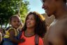 Nyla Harrison looks towards the Supreme Court as she holds her young daughter, Neeralena. Her partner stands next to the both of them, smiling as he looks at Nyla.