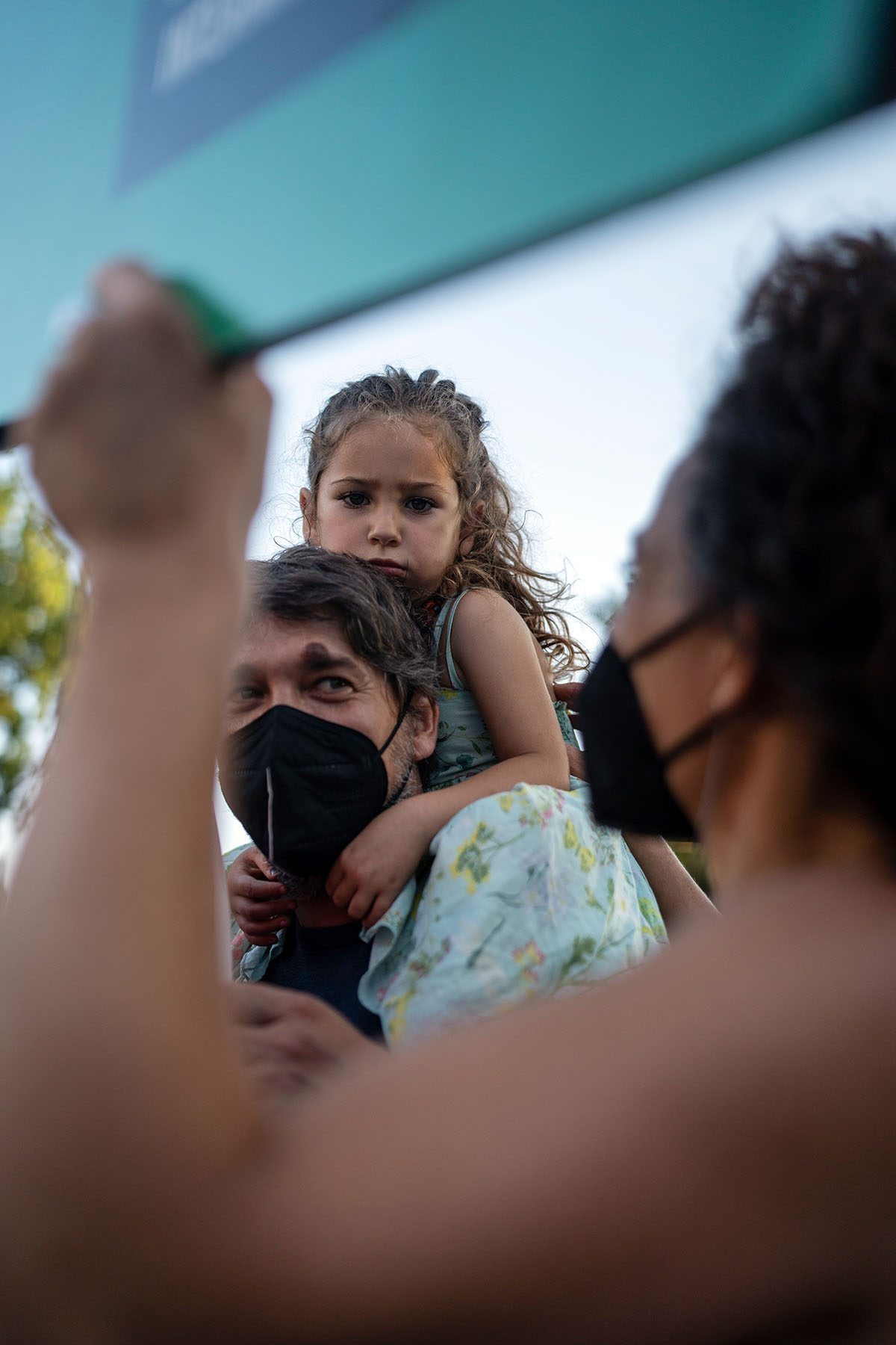 Zora sits on her father's shoulders as her mother looks on.