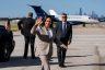 Vice President Kamala Harris waves to the press before boarding Air Force Two. Behind her are two secret service agent and a plane.