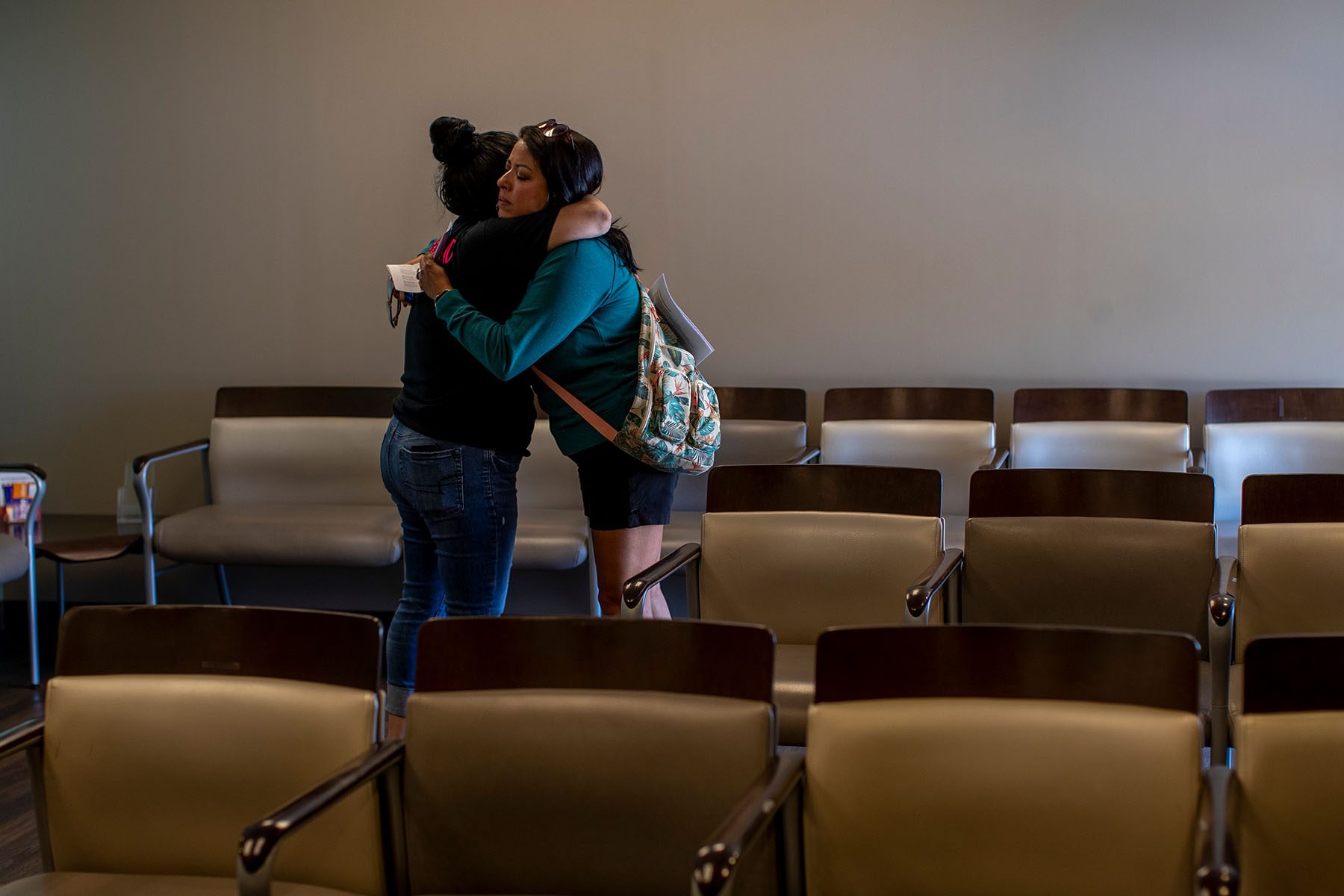 A teary staff member hugs a patient in the clinic's waiting room.