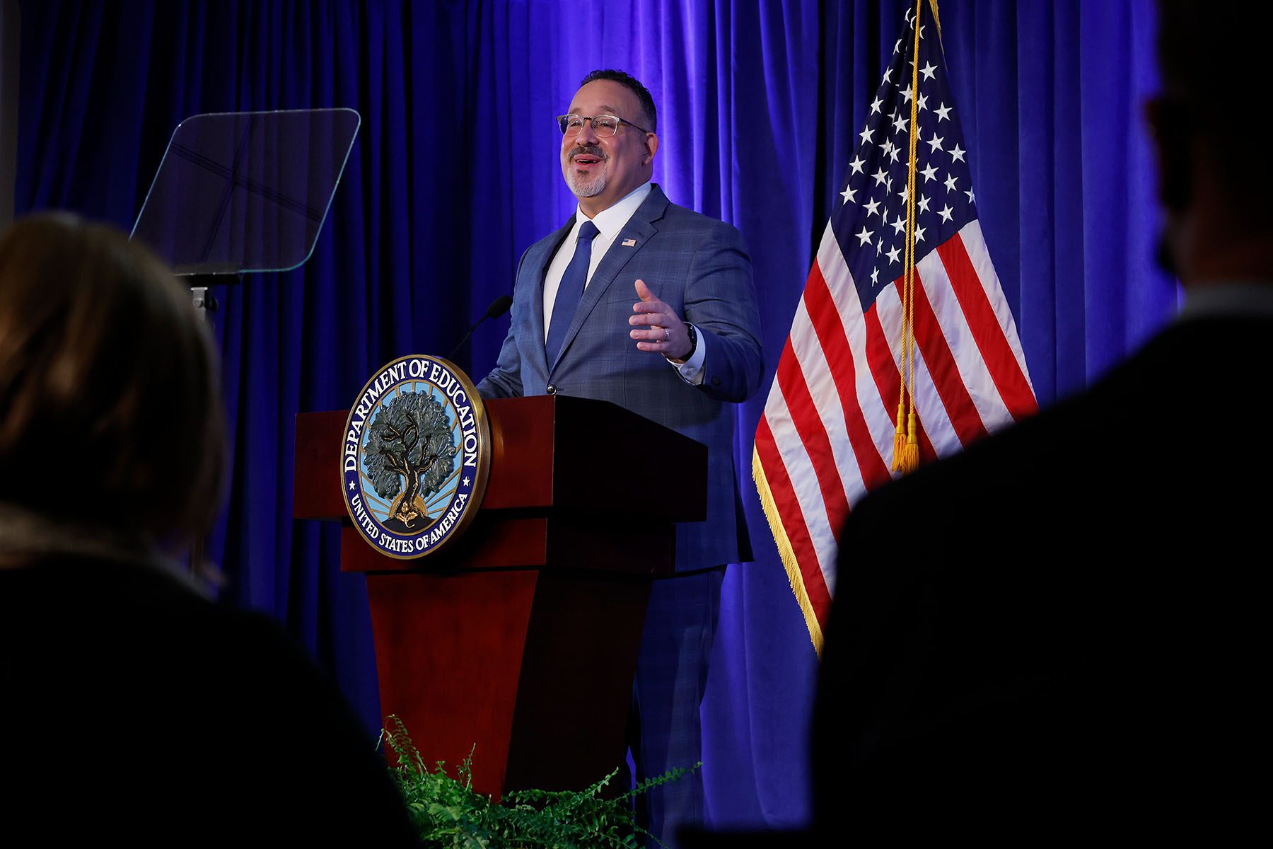 Education Secretary Miguel Cardona delivers remarks at a podium.