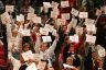 Members and supporters of the Women's Basketball Coaches Association demonstrate in support of Title IX by holding up printed signs that read 