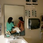 A family physician and her resident perform an ultrasound on a 39-year-old woman in a doctor's office.