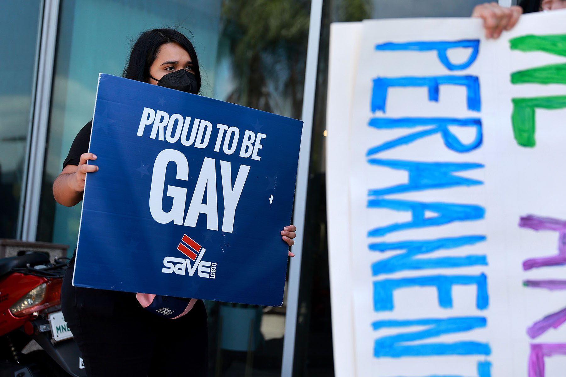 Kimberly Blandon joins others to protest in front of Florida State Senator Ileana Garcia's office after the passage of the "Don't Say Gay" bill. Kimberly is holding a sign that reads "Proud to be gay"