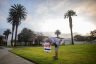 A woman arranges a voting sign near the Main Street Branch Library vote center in the early morning.